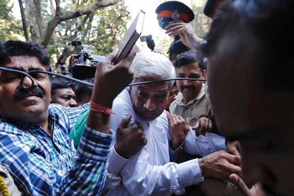 Police escort a man suspected of steering fraudulent loans to companies linked to billionaire jeweller Nirav Modi, at a court in Mumbai, India