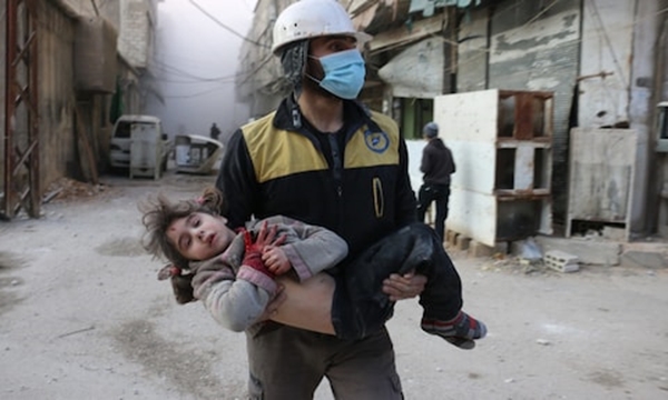 A baby girl is carried to safety in the aftermath of an air strike in Ghouta