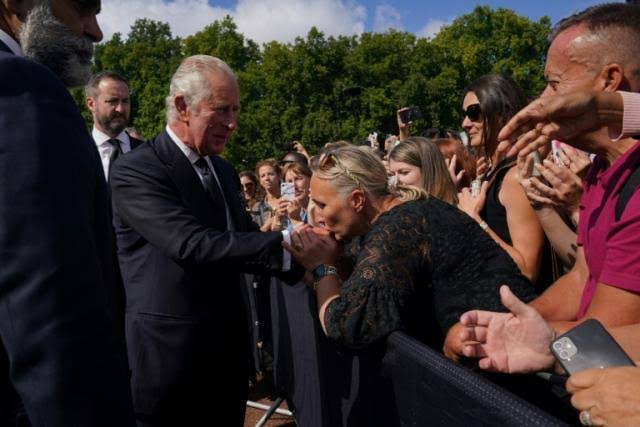 Kisses for King Charles III as he greets crowd at palace